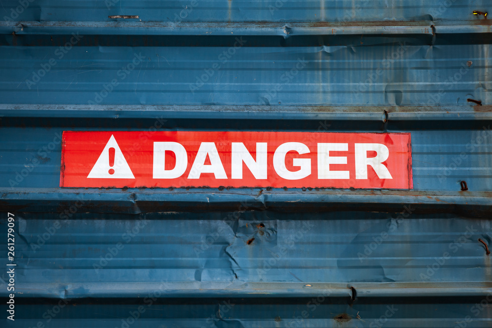 Danger sign on red tape over grungy wall