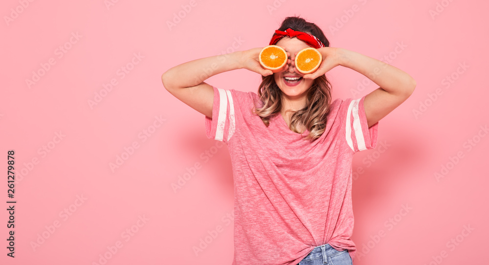 Portrait of a girl with oranges in hand, on a pink background Portrait of a girl with oranges in hand, on a pink background