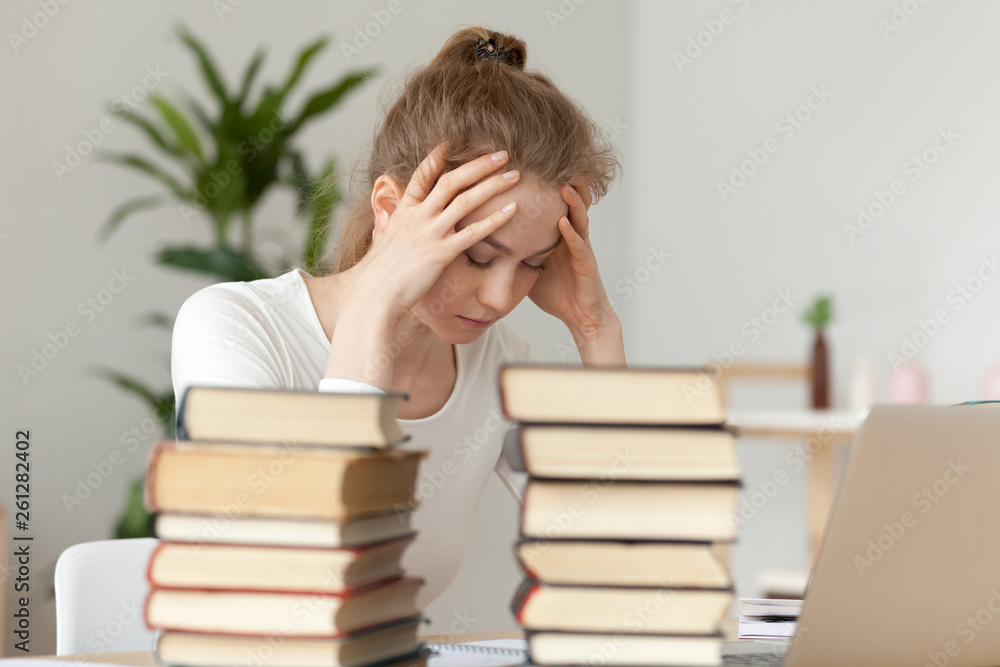Upset woman sitting with closed eyes, annoyed by learning Upset woman sitting with closed eyes, annoyed by learning