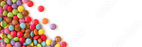 Colorful sugar coated round candies isolated on panoramic white background photo