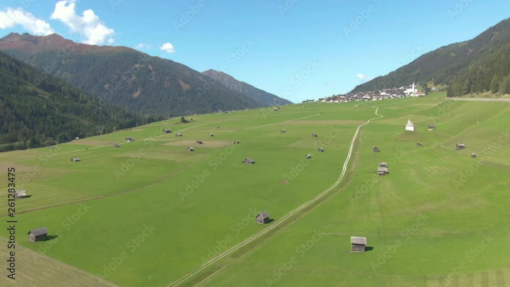 DRONE: Flying above the perfect green meadows in the idyllic Austrian countryside. Picturesque shot of the woods and grassfields surrounding the rural village in sunny Austria. Panoramic landscape DRONE: Flying above the perfect green meadows in the idyllic Austrian countryside. Picturesque shot of the woods and grassfields surrounding the rural village in sunny Austria. Panoramic landscape
