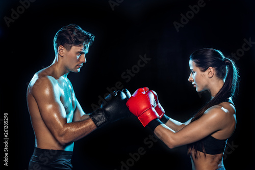 Side view of two boxers in boxing gloves training together isolated on black © LIGHTFIELD STUDIOS