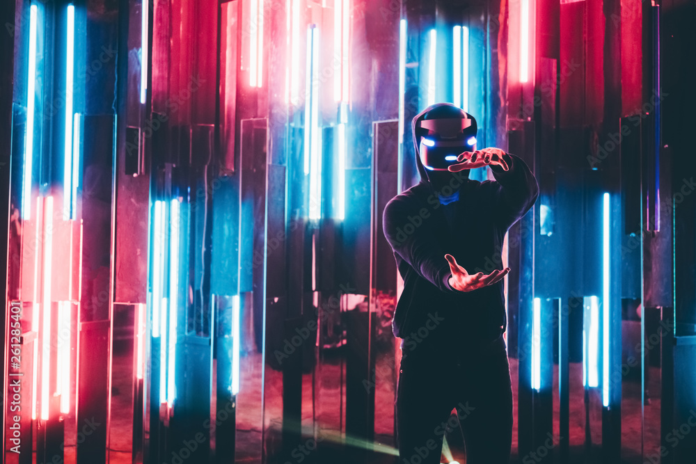 Man using VR headset of augmented reality and moving hands in air like  stretching virtual frame in dark interior illuminated neon light. Stock  Photo | Adobe Stock