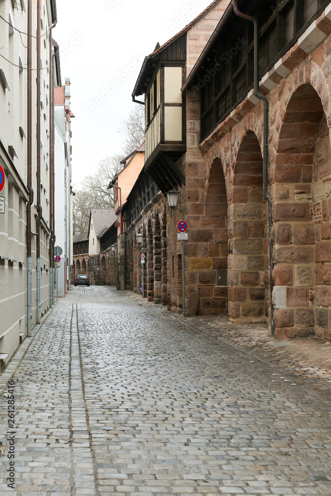 Walkthrough between modern buldings and medieval city wall