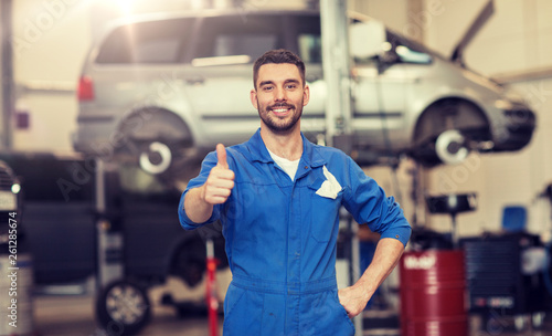car service, repair, maintenance, gesture and people concept - happy smiling auto mechanic man or smith showing thumbs up at workshop © Syda Productions