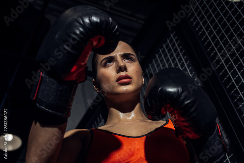 Low angle view of boxer in boxing gloves looking away