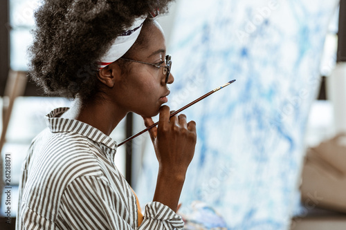 African-American artist feeling thoughtful working on new picture photo