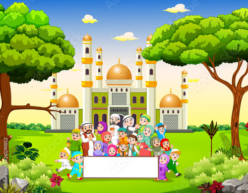 the big happy family are holding the blank banner near the mosque