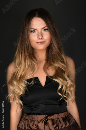 Beautiful smiling woman with clean skin, natural make-up, and white teeth on grey background 