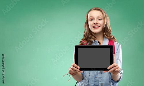 education, school and people concept - happy smiling teenage student girl with bag showing blank tablet computer screen over green chalk board background