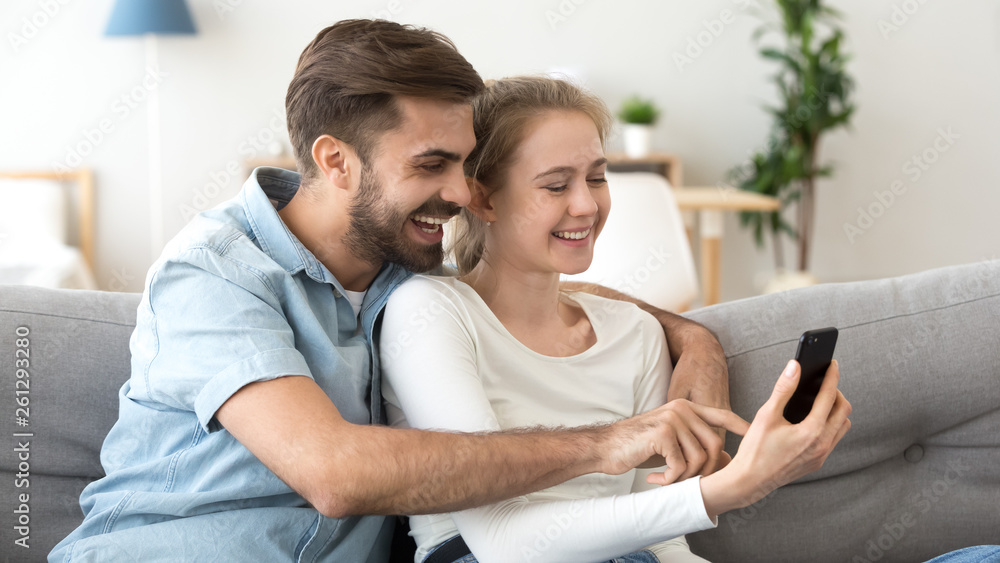 Happy man and woman having fun with smartphone together Happy man and woman having fun with smartphone together