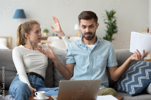 Foto Young married couple check bills, shocked husband hold notification