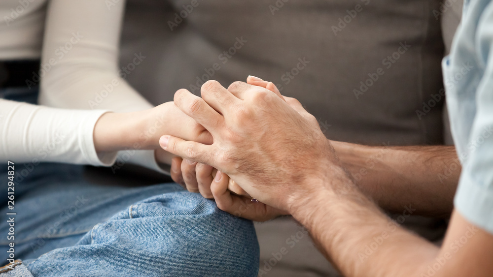 Close up couple in love holding hands, showing support, togetherness Close up couple in love holding hands, showing support, togetherness