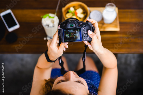 beautiful female photographs her food on camera. foodblogger photo