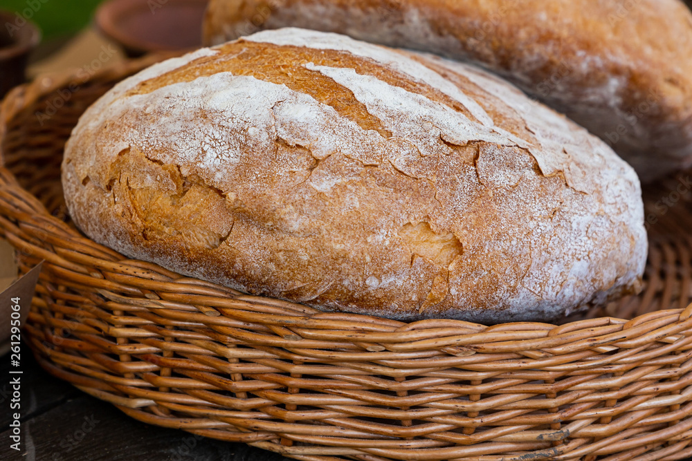 loaf bread round fresh delicious whole-grain brown in a wicker basket close-up