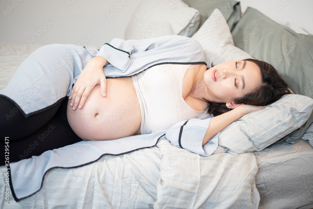 Beautiful asian pregnant woman is sleeping on bed Beautiful asian pregnant woman is sleeping on bed