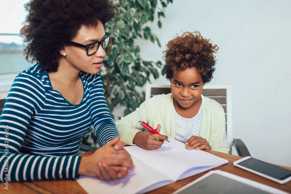 Naklejka premium Mother and daughter doing homework learning to calculate