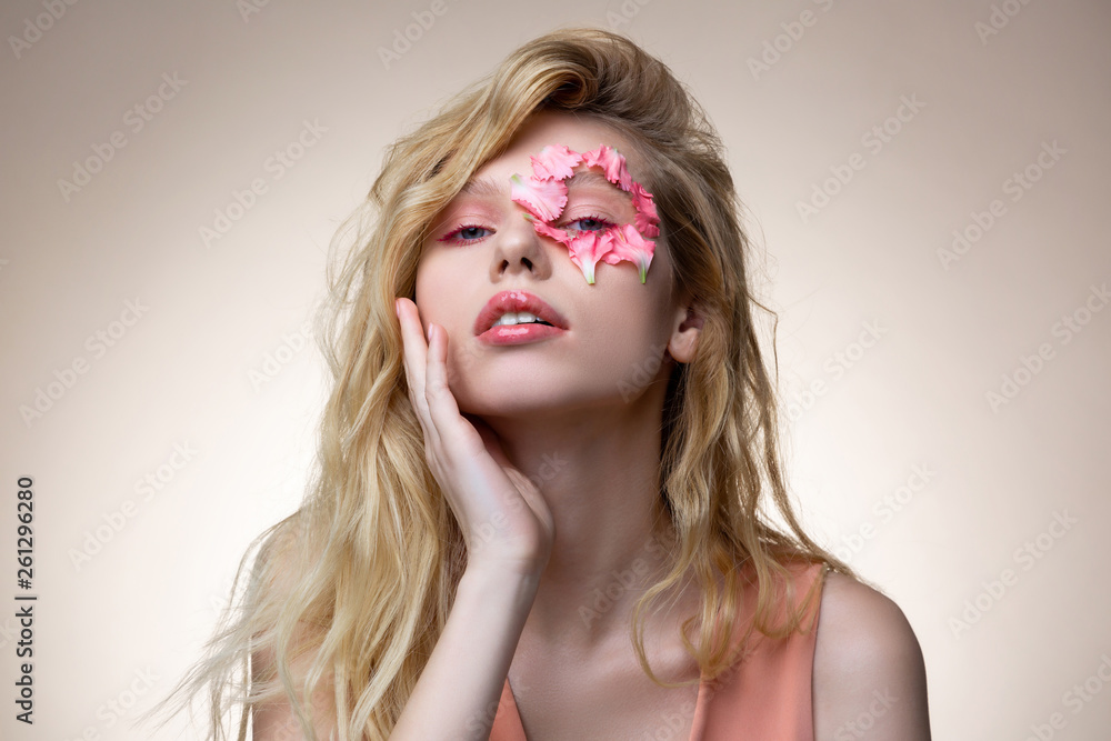 Tender blonde model wearing pink dress having pink makeup