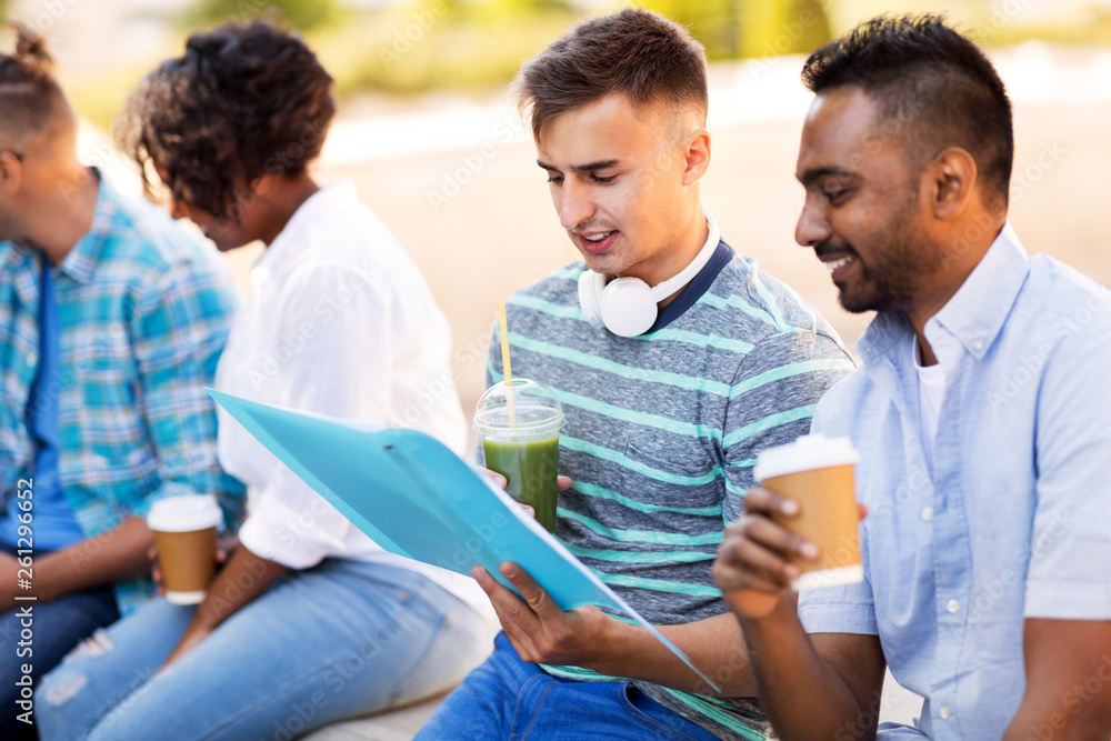 education, international and people concept - group of happy exchange students with notebook and takeaway drinks outdoors education, international and people concept - group of happy exchange students with notebook and takeaway drinks outdoors