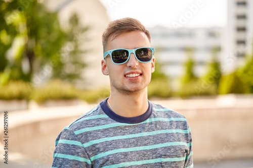 people concept - portrait of young man in sunglasses outdoors in summer city