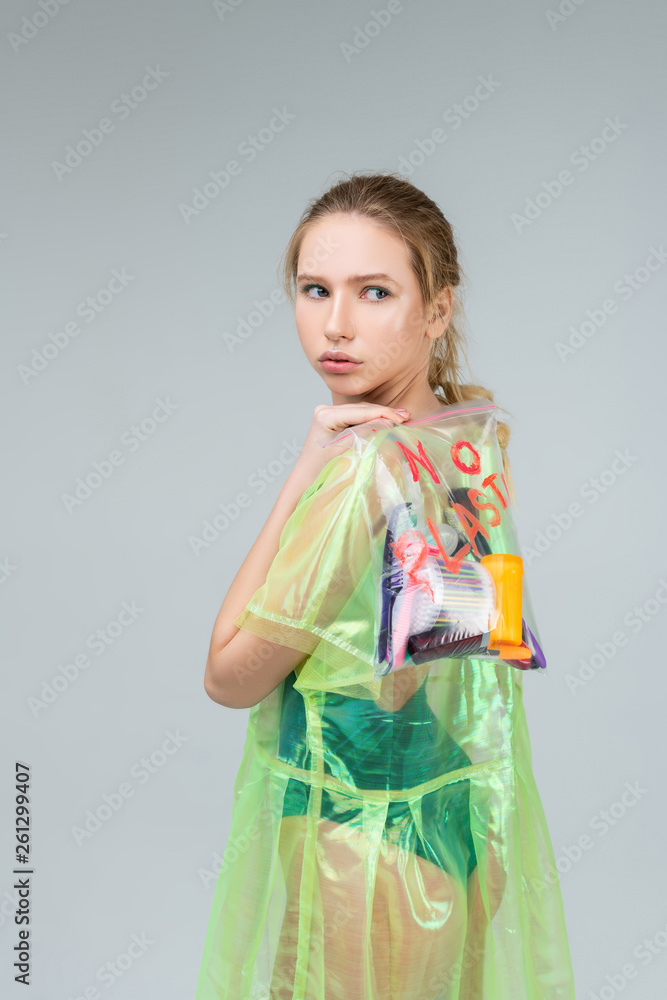 Serious blonde woman caring transparent bag full of plastic Serious blonde woman caring transparent bag full of plastic