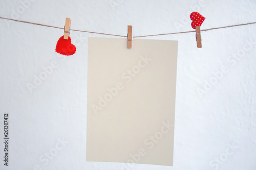 Hearts hang on clothespins on a white background..Nick with hearts hanging on it and empty sheets..Pattern for Valentine's day.