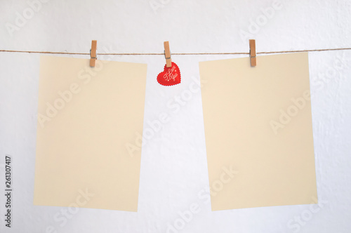 Hearts hang on clothespins on a white background..Nick with hearts hanging on it and empty sheets..Pattern for Valentine's day.