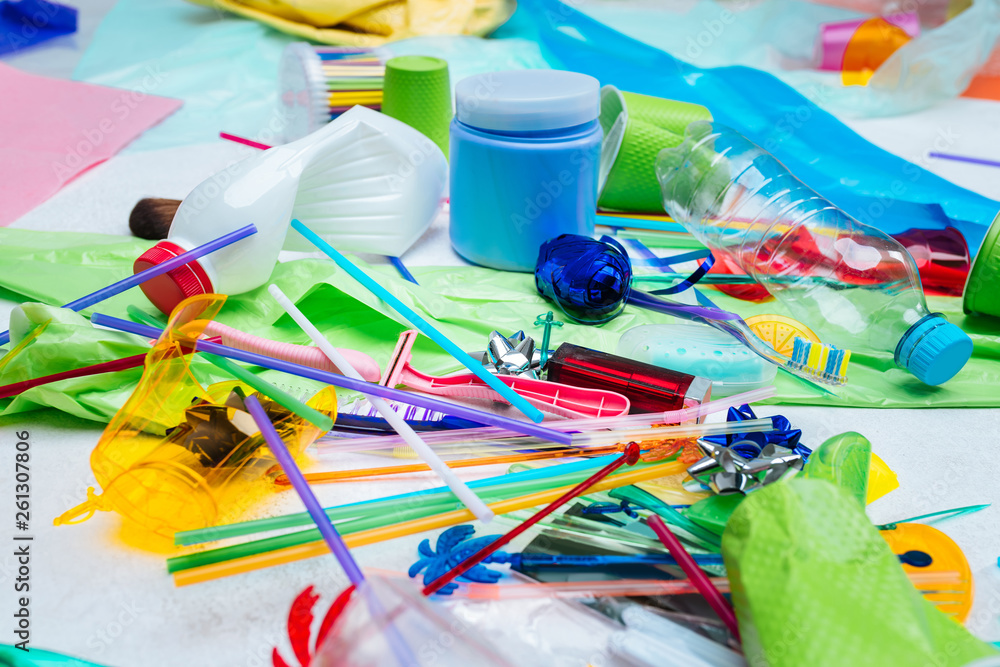 Fototapeta premium Close up of plastic bottle and packs lying near colorful straws
