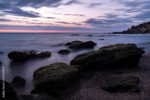 Long exposure photography of the sea at the blue hour with rocks in Creek of Roche,Cadiz (Spain).