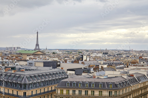 Paris rooftops view and Eiffel Tower in a cloudy day in France