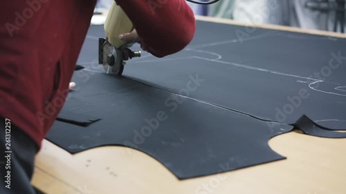 Tailor at work. Close up cutting fabric for suit.