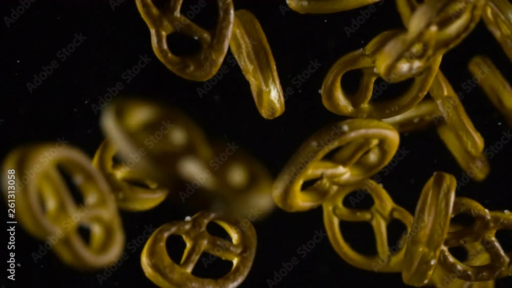 Crispy Beer Pretzels. Baked pretzels emerge from the darkness, hovering in front of the camera and then disappear in the shadows. Slow Motion at a rate of 240 fps Crispy Beer Pretzels. Baked pretzels emerge from the darkness, hovering in front of the camera and then disappear in the shadows. Slow Motion at a rate of 240 fps