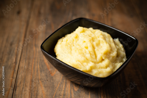 Mashed potatoes in the bowl on the white wooden table