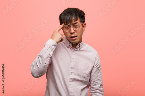 Young chinese man doing a disappointment gesture with finger