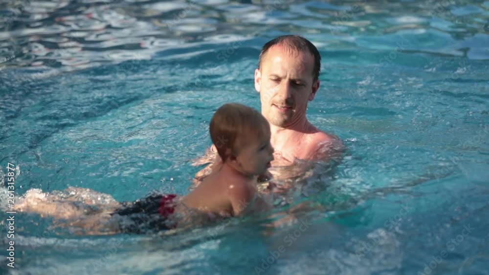 Father and son having fun in pool next to the beach in Mauritius Father and son having fun in pool next to the beach in Mauritius