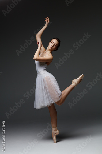 Young beautiful ballerina is posing in studio