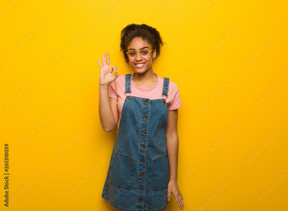 Young black african american girl with blue eyes cheerful and confident doing ok gesture Young black african american girl with blue eyes cheerful and confident doing ok gesture