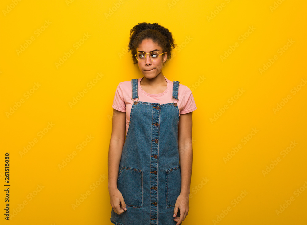 Young black african american girl with blue eyes thinking about an idea Young black african american girl with blue eyes thinking about an idea