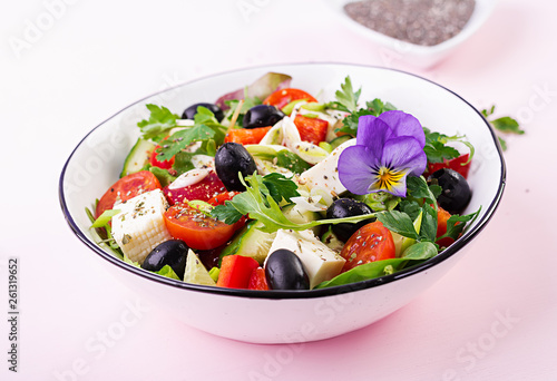 Greek salad with cucumber, tomato, sweet pepper, lettuce, green onion, feta cheese and olives with olive oil. Healthy food.