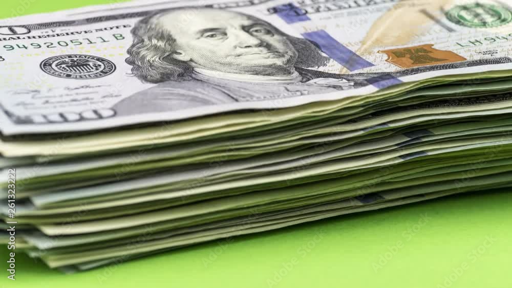 Wealth growth / earning money concept. Bundle of US dollars increases one by one bill, gradually turning into a big pile. Stop motion animation. Wealth growth / earning money concept. Bundle of US dollars increases one by one bill, gradually turning into a big pile. Stop motion animation.