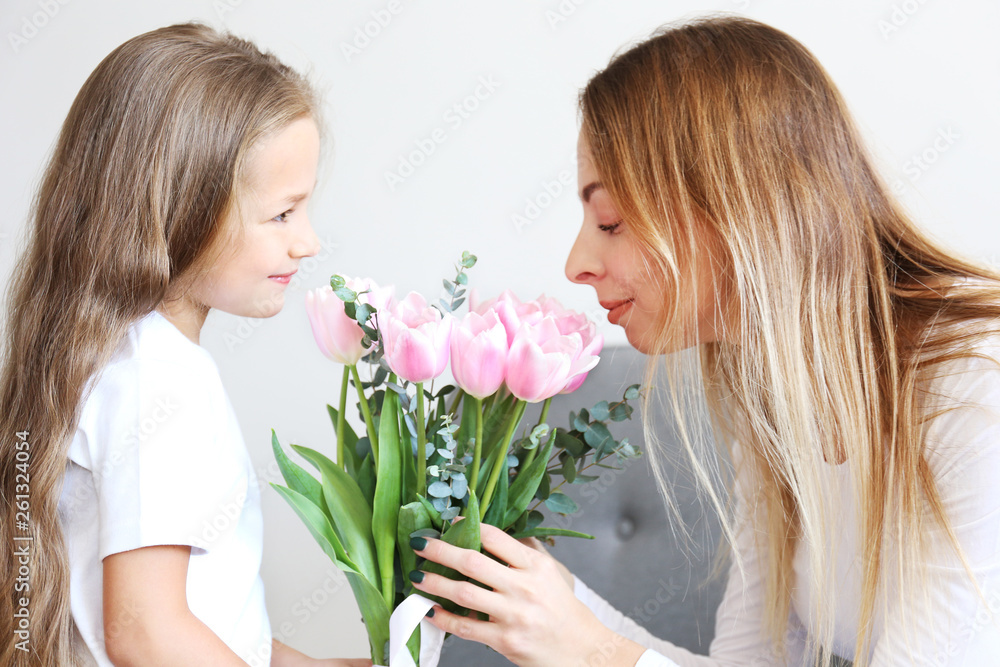 Cute little five year old girl giving her mom a present for mothers day. Adorable scene with daughter surprizing her mum. Close up, background, portrait. Cute little five year old girl giving her mom a present for mothers day. Adorable scene with daughter surprizing her mum. Close up, background, portrait.
