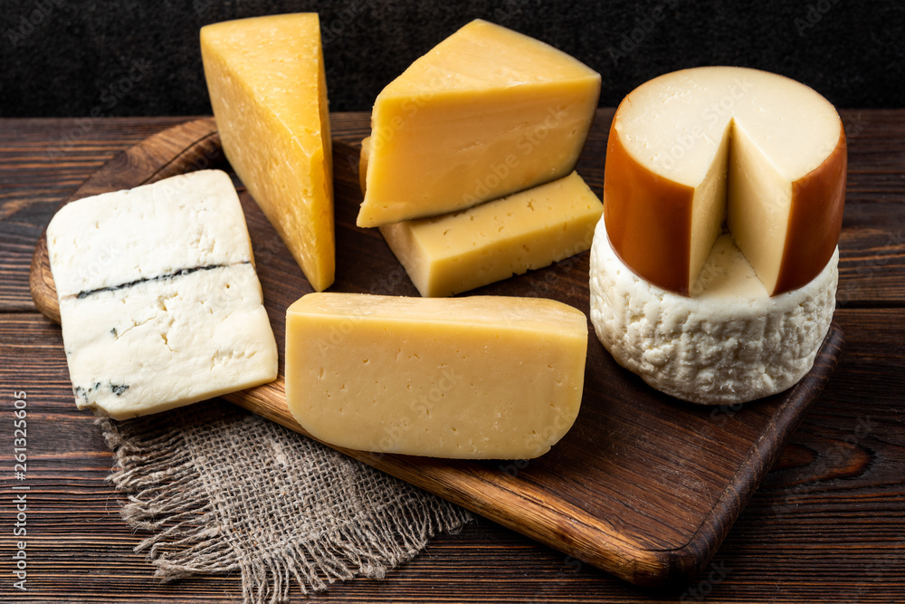 Cheese on dark wooden background.