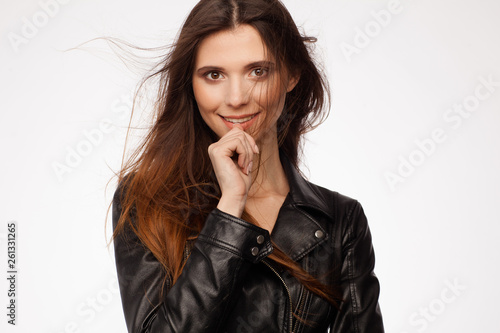 Portrait of a beautiful sexy model in black leather jacket. Hair in the wind