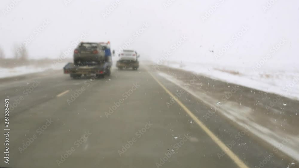dangerous route in ice and blizzard, two tow trucks transporting cars dangerous route in ice and blizzard, two tow trucks transporting cars