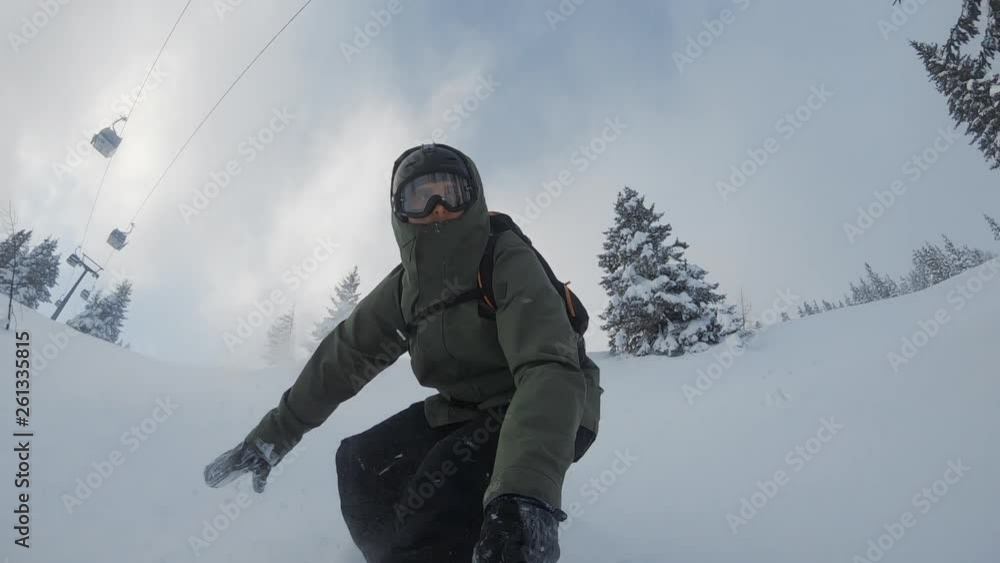 ACTION: A snowboarder rides through deep snow on a steep hill and does quick turns in the fresh powder. A friend joins him in the background. Winter sports activities in frozen wonderland. ACTION: A snowboarder rides through deep snow on a steep hill and does quick turns in the fresh powder. A friend joins him in the background. Winter sports activities in frozen wonderland.