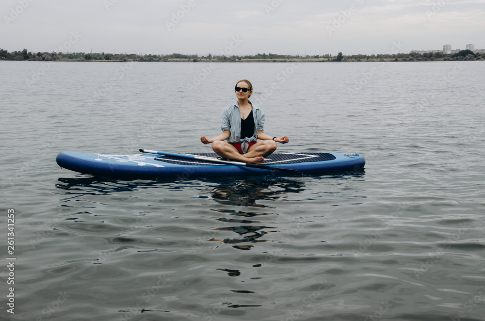 Girl on stand up paddle board. Woman practicing SUP yoga, meditating on a paddle board. Woman on sup board. Girl on stand up paddle board. Woman practicing SUP yoga, meditating on a paddle board. Woman on sup board.