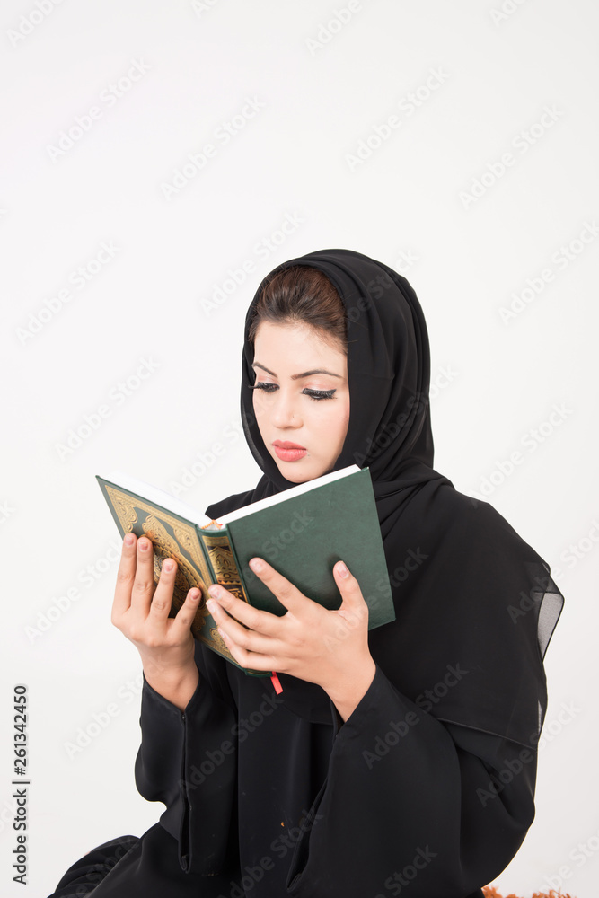 Arab muslim woman reading the holy Quran and praying Arab muslim woman reading the holy Quran and praying