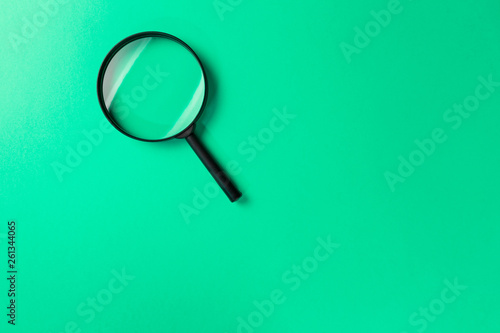 Magnifying glass on Mint background. Top view. Flat lay. Copy space. Minimal creative concept. Search concept. Neo Mint color of the year 2020
