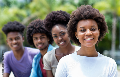 Happy african american woman with group of young adults in line