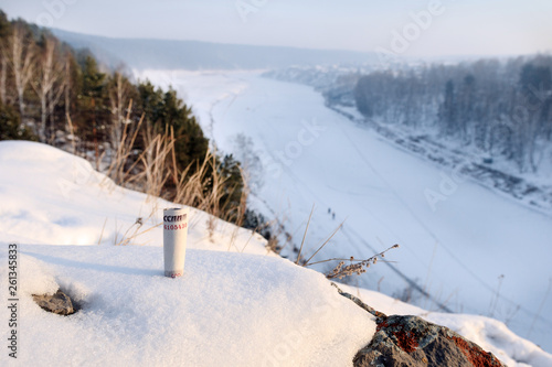 rolled up paper bill inserted into the snow on top of the mountain